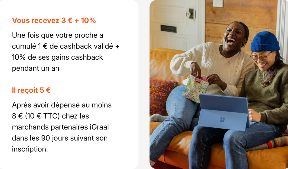 Deux femmes souriantes sur un canapé, regardant un ordinateur portable et un cadeau.