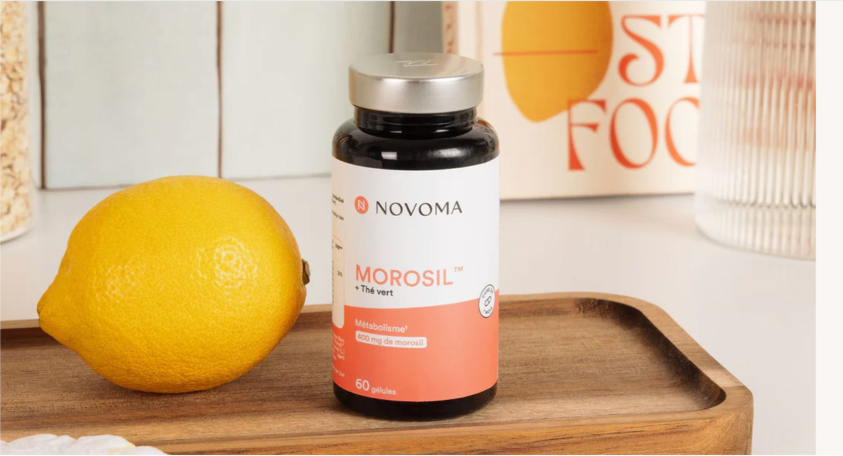 Bouteille de gélules Morosil à côté d'un citron sur une planche en bois.