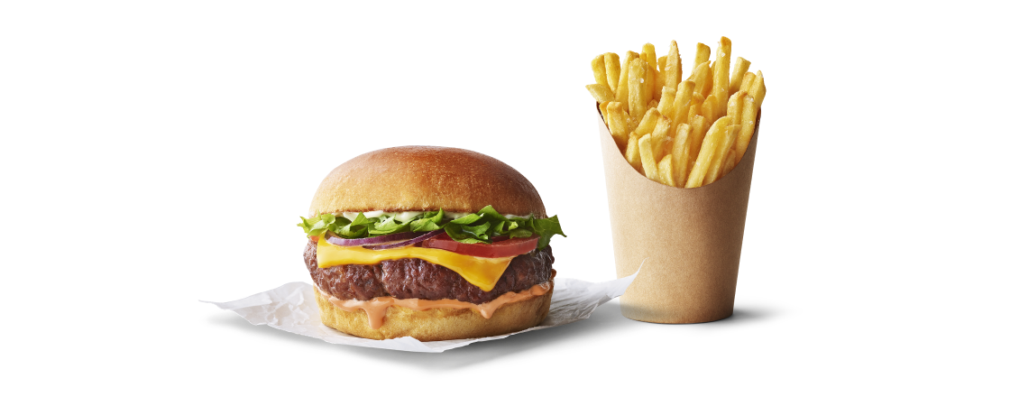 Burger avec salade, fromage et sauce, accompagné de frites dorées dans un cornet.